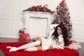 Christmas girl holidays. Happy New Year background. Beautiful brunette in woolen sweater and knee high socks lying on fur plaid by