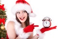 Christmas girl in santa hat and fir tree, clock. Royalty Free Stock Photo