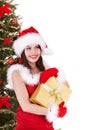 Christmas girl in santa hat with gift box. Tree. Royalty Free Stock Photo