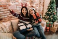 Christmas girls showing presents to cellphone. Royalty Free Stock Photo