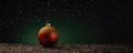 Christmas glass ball hanging on blurred dark green snowy background with snowflakes. Christmas tree toy Royalty Free Stock Photo