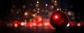 Christmas glass ball hanging on blurred dark red snowy background with bokeh golden lights. Royalty Free Stock Photo