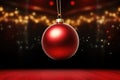 Christmas glass ball hanging on blurred dark red snowy background with bokeh golden lights. Royalty Free Stock Photo