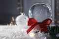 Christmas glass globe with artificial snow against blurred background Royalty Free Stock Photo