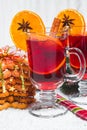 Christmas glass of red mulled wine on table with cinnamon sticks, branches of Christmas tree, snow, Royalty Free Stock Photo