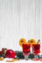 Christmas glass of red mulled wine on table with cinnamon sticks, branches of Christmas tree, snow, Royalty Free Stock Photo