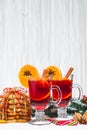 Christmas glass of red mulled wine on table with cinnamon sticks, branches of Christmas tree, snow, Royalty Free Stock Photo