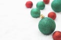 Christmas glitered green and red baubles, balls isolated on snow. Winter greeting card with copy space Royalty Free Stock Photo