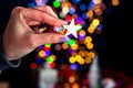 Christmas glittery star decoration isolated on background with blurred lights.