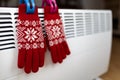 Christmas gloves on a radiator in a cold winter day, energy crisis, power saving Royalty Free Stock Photo