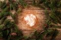 Christmas glowing ball on wooden background with fir branches, spruce, juniper, fir, larch, pine cones