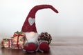 Christmas gnome with gift and pine cone. With copy space