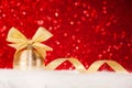 Christmas gold ball and bow on red glitter shiny background Royalty Free Stock Photo