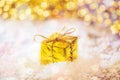 Christmas gold box in the snow with background light on wooden table. golden and white ornaments Royalty Free Stock Photo