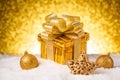 Christmas gold gift box with balls and decoration on snow Royalty Free Stock Photo