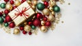 Christmas gold gift box with red ribbon and ornaments, gold red and green shiny baubles on white backdrop, Merry Christmas Royalty Free Stock Photo