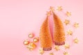 Christmas gold glitter background with Christmas trees, decorations, stars garland on soft light pink pastel color, top view. Royalty Free Stock Photo