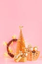 Christmas gold glitter decorations with Christmas tree, stars garland and wreath on soft light pink pastel background, vertical. Royalty Free Stock Photo