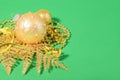 Christmas golden ball with golden Christmas decoration on a green paper Royalty Free Stock Photo