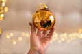 A Christmas golden ball in a woman`s hand with a reflection of a family of four. Royalty Free Stock Photo