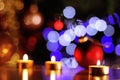 Christmas fairy lights with candles, red baubles and glittering tree lights Royalty Free Stock Photo