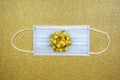 Christmas golden deco baubles on golden background with surgical protective mask. New year on quarantine. Flat lay design. Copy