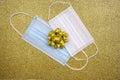 Christmas golden deco baubles on golden background with two surgical protective masks: for adult and for child. New year on