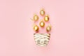 Christmas golden decoration as festive bright background with gold glittering balls, ribbon, bowl flying on pastel pink color.