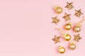 Christmas golden decoration as festive bright background with gold stars, glittering balls, ribbon on pastel pink color, top view. Royalty Free Stock Photo