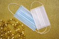 Christmas golden decorative ornaments on golden background with two surgical protective masks: for adult and for child. New year