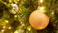 Christmas golden glister ball hanging on pine tree.