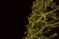 Christmas golden yellow mesh garland on fir tree at night