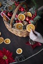 female hand collects a wicker basket with Christmas decorations and goods as a gift Royalty Free Stock Photo