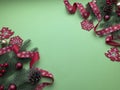 Christmas green background with red ribbon ornaments and pinecones