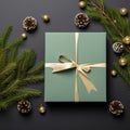 Christmas green gift box with golden bow and fir tree branches on black background Royalty Free Stock Photo