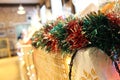 Christmas green and red tinsel decorates a table at exhibition.