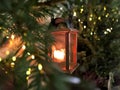 Christmas green tree branch orange candle lantern bokeh light snow flakes background holiday Royalty Free Stock Photo