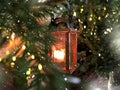 Christmas green tree branch orange candle lantern bokeh light snow flakes background holiday Royalty Free Stock Photo