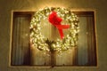 Christmas green wreath with red ribbon on the front door. Entrance to the house decorated for the winter holiday - Xmas and New Royalty Free Stock Photo