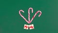 Christmas greeting card. ÃÂ¡andy canes decorated with gift boxes and sprigs of spruce appears on viridian green background.