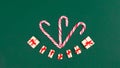 Christmas greeting card. ÃÂ¡andy canes decorated with gift boxes and sprigs of spruce on viridian green background. Template for