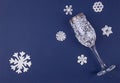 Christmas greeting card with decoration snoflakes made of sugar icing and wine glass decorated with icing on deep blue background
