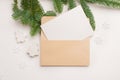 Christmas greeting card with envelope on wooden white background with fir tree branches and happy new year decorations Royalty Free Stock Photo