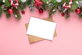 Christmas greeting card or festive invitation with fir tree, holiday decorations on pink background. Flat lay. Mock up Royalty Free Stock Photo