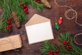 Christmas greeting card with fir tree branch, gifts, present box and envelope. Wooden background Top view Royalty Free Stock Photo