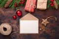 Christmas greeting card with fir tree branch, gifts, present box and envelope. Wooden background Top view Royalty Free Stock Photo