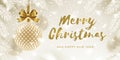 Christmas greeting card. Glitter gold brush calligraphy greeting and patterned golden bauble with bow hanging on a christmas tree. Royalty Free Stock Photo