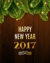 Christmas Greeting Card. Inscription with Christmas and new year 2017 against wooden texture and branches of a New Year\'s tree