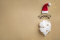 Christmas greeting card, invitation or flyer. Santa hat, beard and glasses on golden background with confetti stars