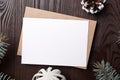 Christmas greeting card mockup with envelope, green fir tree branches and decorations on brown wooden background, top view, flat Royalty Free Stock Photo